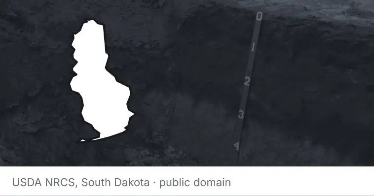 A soil profile in an open pit, under the outline of Baldwin County. The source names South Dakota.