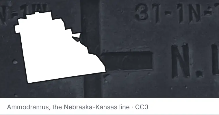 A survey monument's crosshair, under the outline of Polk County. The source names the Nebraska-Kansas line.