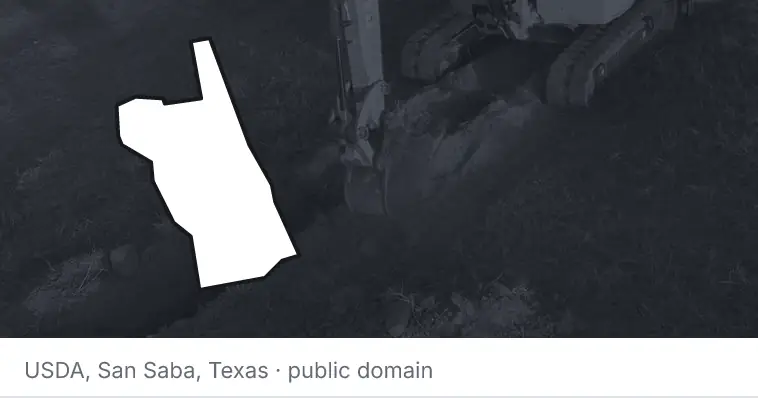 An excavator cutting a trench, under the outline of St. Johns County. The source names San Saba, Texas.