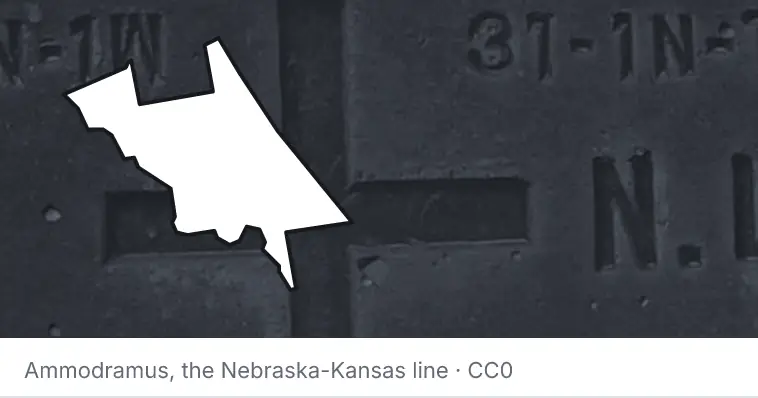 A survey monument's crosshair, under the outline of Volusia County. The source names the Nebraska-Kansas line.