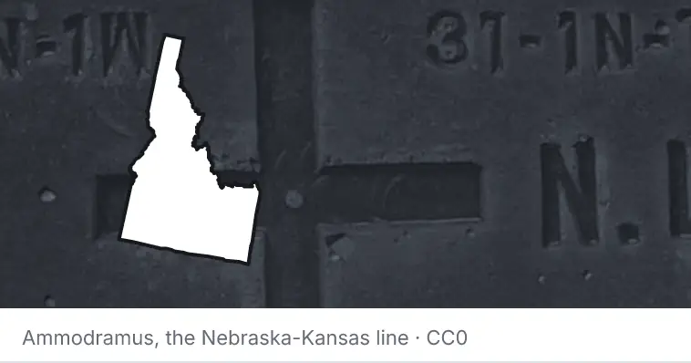 A survey monument's crosshair, under the outline of Idaho. The source names the Nebraska-Kansas line.