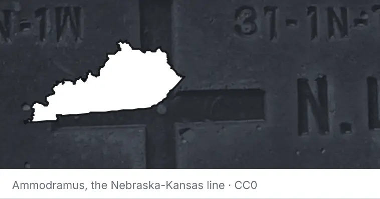 A survey monument's crosshair, under the outline of Kentucky. The source names the Nebraska-Kansas line.