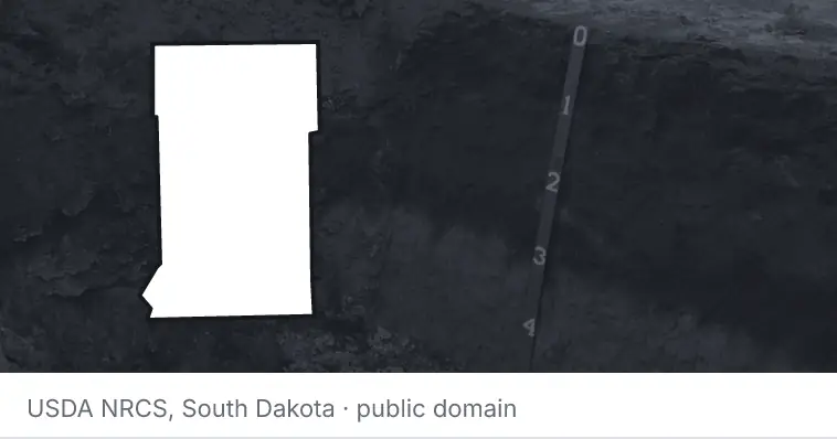 A soil profile in an open pit, under the outline of Crow Wing County. The source names South Dakota.