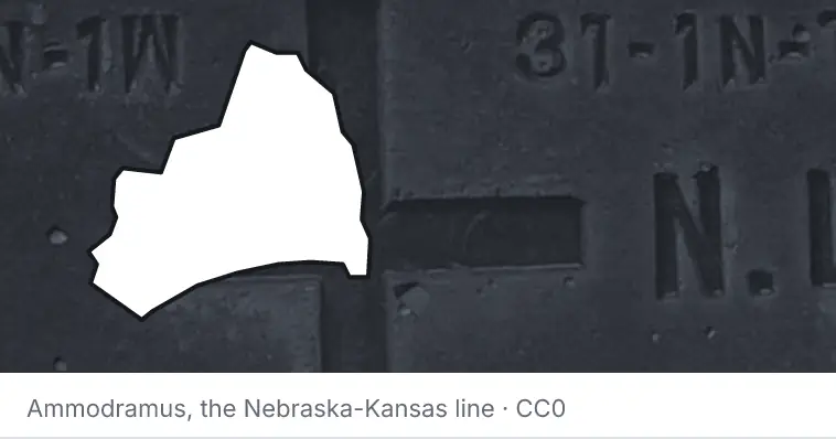 A survey monument's crosshair, under the outline of Brunswick County. The source names the Nebraska-Kansas line.