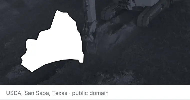 An excavator cutting a trench, under the outline of Brunswick County. The source names San Saba, Texas.