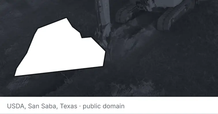 An excavator cutting a trench, under the outline of Catawba County. The source names San Saba, Texas.
