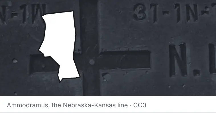 A survey monument's crosshair, under the outline of Iredell County. The source names the Nebraska-Kansas line.
