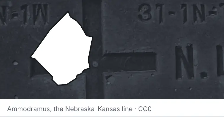 A survey monument's crosshair, under the outline of Johnston County. The source names the Nebraska-Kansas line.