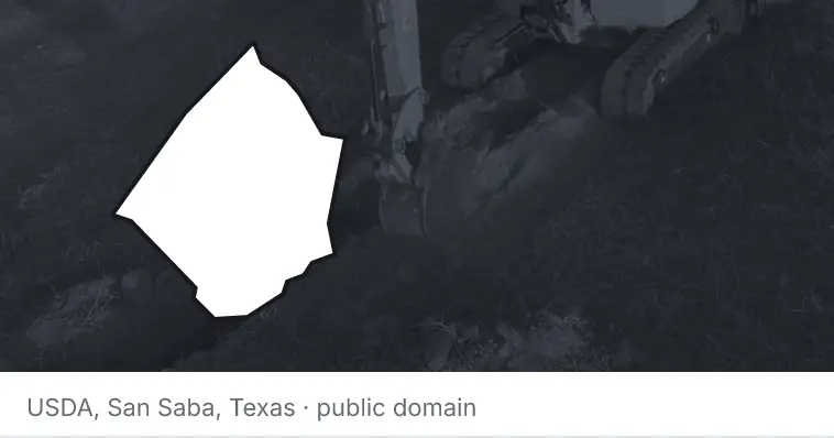 An excavator cutting a trench, under the outline of Johnston County. The source names San Saba, Texas.