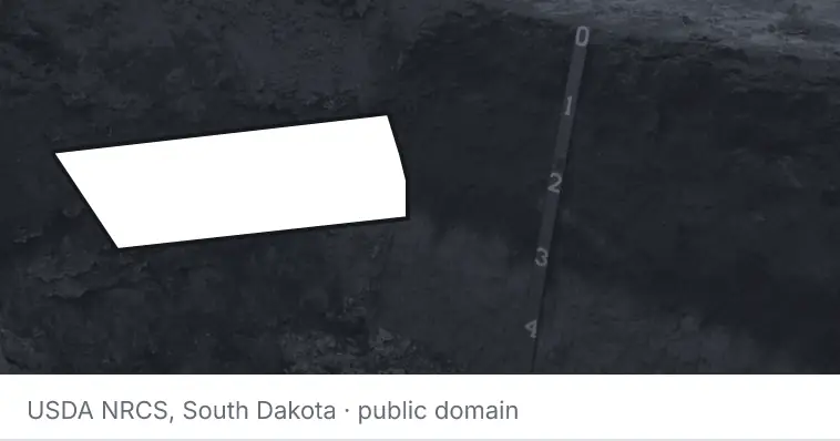 A soil profile in an open pit, under the outline of Lincoln County. The source names South Dakota.