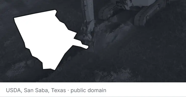 An excavator cutting a trench, under the outline of Moore County. The source names San Saba, Texas.