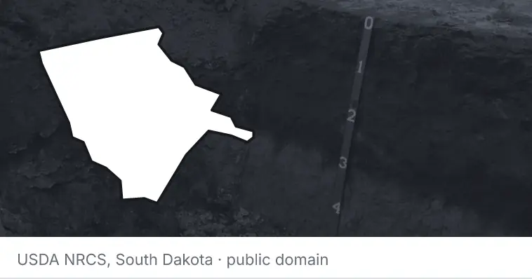 A soil profile in an open pit, under the outline of Moore County. The source names South Dakota.