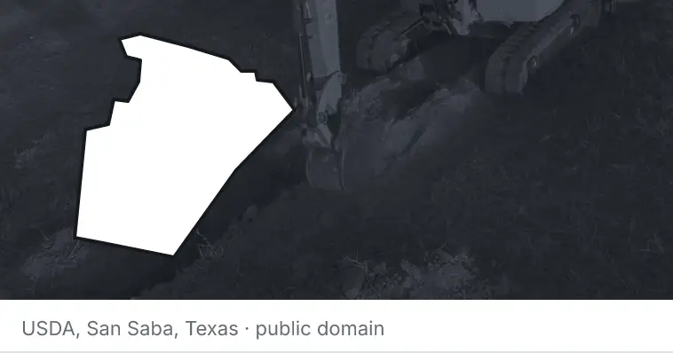 An excavator cutting a trench, under the outline of Wake County. The source names San Saba, Texas.