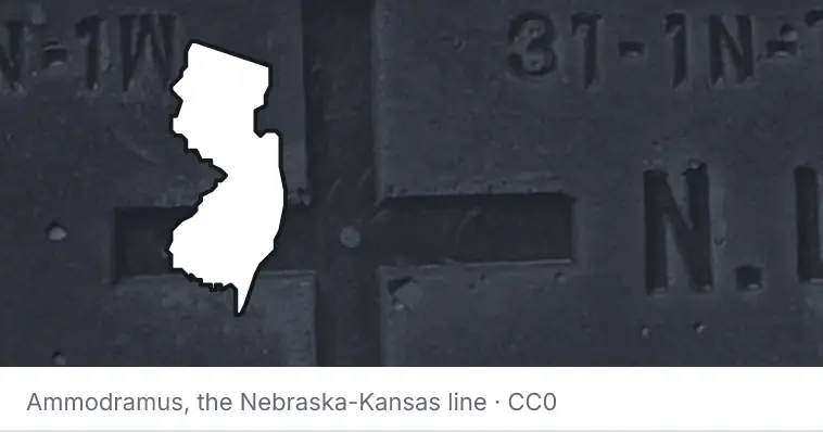 A survey monument's crosshair, under the outline of New Jersey. The source names the Nebraska-Kansas line.