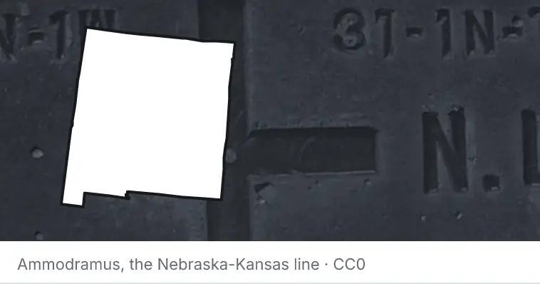 A survey monument's crosshair, under the outline of New Mexico. The source names the Nebraska-Kansas line.