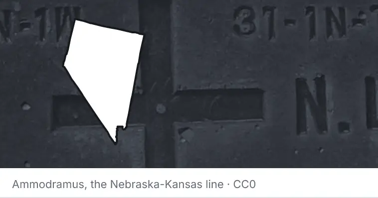 A survey monument's crosshair, under the outline of Nevada. The source names the Nebraska-Kansas line.