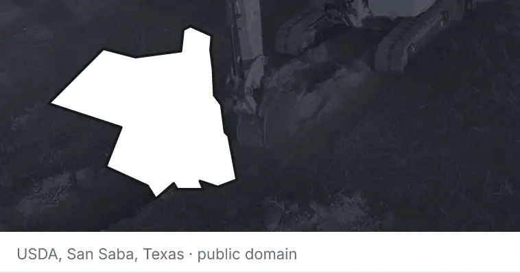 An excavator cutting a trench, under the outline of Ulster County. The source names San Saba, Texas.