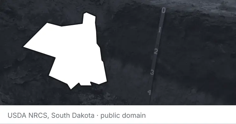 A soil profile in an open pit, under the outline of Ulster County. The source names South Dakota.
