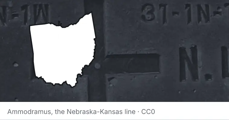 A survey monument's crosshair, under the outline of Ohio. The source names the Nebraska-Kansas line.