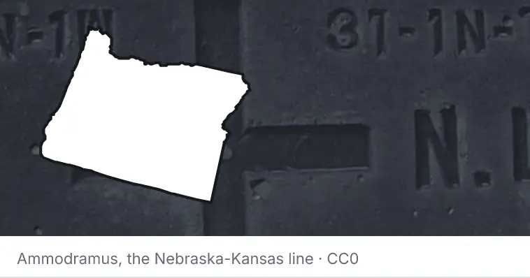 A survey monument's crosshair, under the outline of Oregon. The source names the Nebraska-Kansas line.
