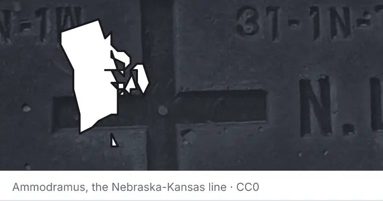 A survey monument's crosshair, under the outline of Rhode Island. The source names the Nebraska-Kansas line.