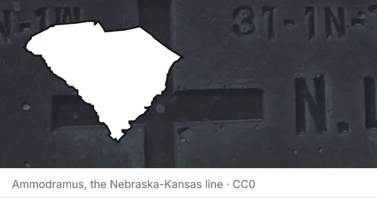 A survey monument's crosshair, under the outline of South Carolina. The source names the Nebraska-Kansas line.