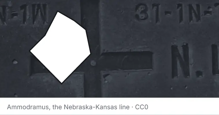 A survey monument's crosshair, under the outline of Bastrop County. The source names the Nebraska-Kansas line.