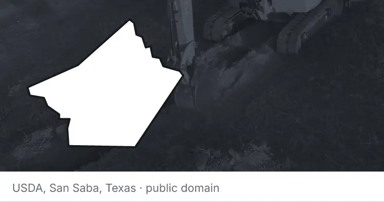 An excavator cutting a trench, under the outline of Guadalupe County. The source names San Saba, Texas.