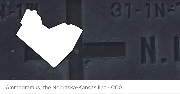 A survey monument's crosshair, under the outline of Travis County. The source names the Nebraska-Kansas line.