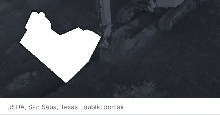 An excavator cutting a trench, under the outline of Travis County. The source names San Saba, Texas.
