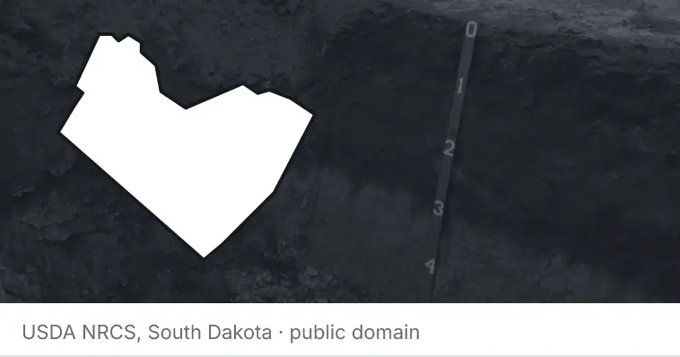 A soil profile in an open pit, under the outline of Travis County. The source names South Dakota.