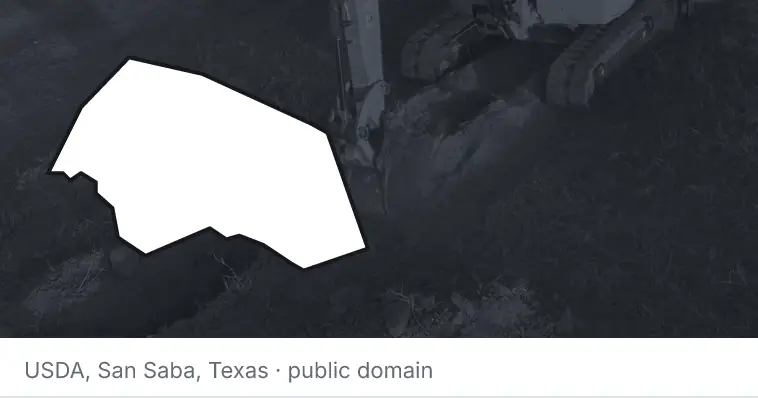 An excavator cutting a trench, under the outline of Williamson County. The source names San Saba, Texas.