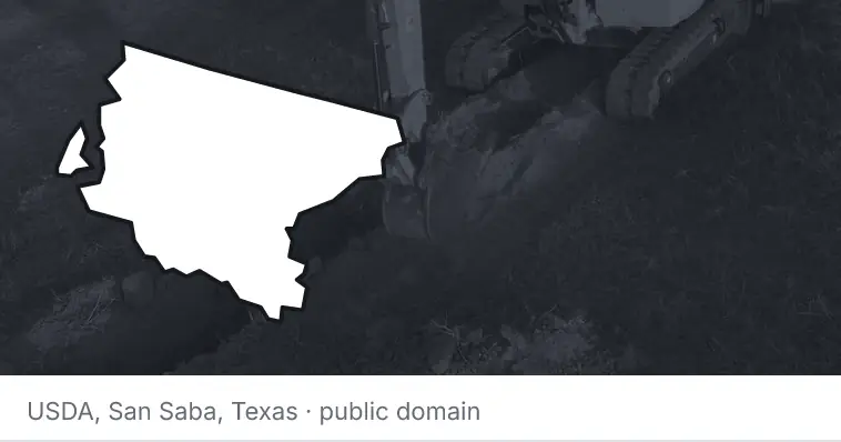 An excavator cutting a trench, under the outline of King County. The source names San Saba, Texas.